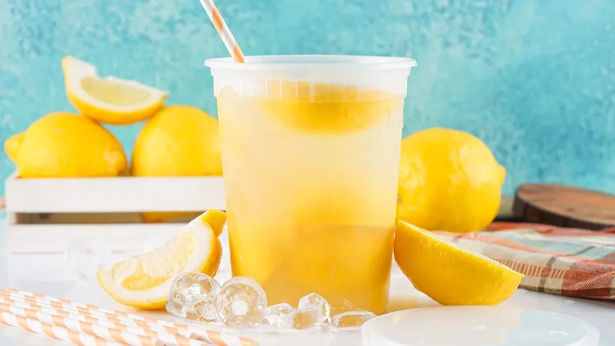 Cup of fresh-squeezed lemonade with lemon wedges